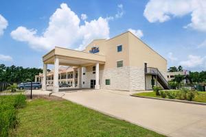 un gran edificio blanco con aparcamiento en Baymont by Wyndham Kingwood, en Kingwood