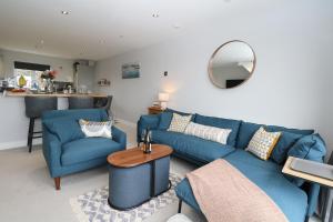a living room with blue couches and a mirror at Ocean View in South Hayling