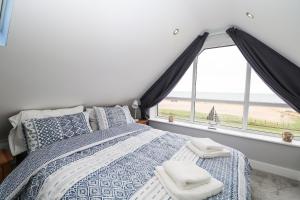 1 dormitorio con cama y ventana grande en Ocean View en South Hayling