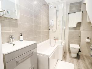 a bathroom with a sink and a toilet and a shower at Ocean View in South Hayling