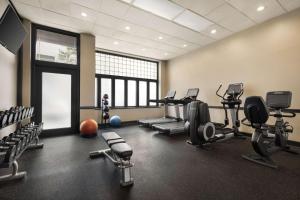 a gym with several treadmills and cardio machines at The Admiral Hotel in Mobile