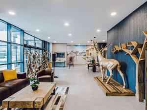 a living room with a couch and a statue of a deer at ibis Styles Contres-Cheverny 