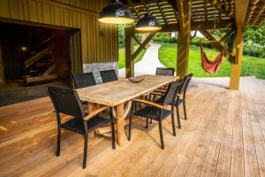 una mesa de comedor de madera y sillas en una terraza en L'ilet aux 2 étangs en Saint-Nabord