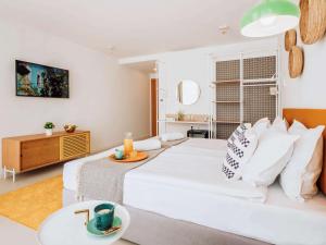 a bedroom with a white bed and a living room at ibis Styles Golden Sands Roomer Hotel in Golden Sands +37 photos
