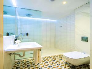 a bathroom with a sink and a toilet and a shower at ibis Styles Golden Sands Roomer Hotel in Golden Sands