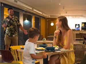 a woman and a boy sitting at a table eating food at ibis Styles Golden Sands Roomer Hotel in Golden Sands