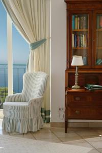 a room with a chair and a desk with a lamp at Hotel Caesar Augustus in Anacapri