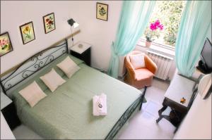 um quarto com uma cama, uma cadeira e uma janela em Hotel Casa Nicola em Ischia
