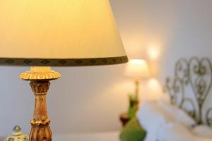 a lamp sitting on a table next to a bed at Hotel Caesar Augustus in Anacapri