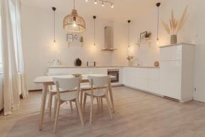 a white kitchen with a table and white cabinets at ZION Apartments in Neuwied