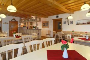 a dining room with white tables and white chairs at Pension Zum Lebzelter in Freyung