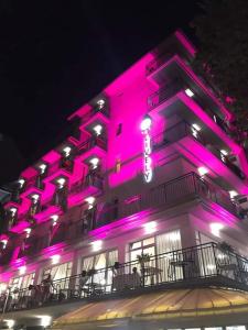 un bâtiment avec des lumières roses sur son côté dans l'établissement Lively Hotel, à Bellaria-Igea Marina