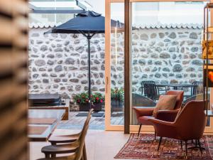eine Terrasse mit Stühlen, einem Tisch und einem Sonnenschirm in der Unterkunft Sweet Piccolo Loft in centro con incantevole idromassaggio in Meran