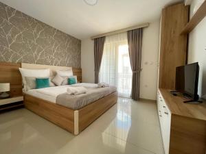 a bedroom with a bed and a flat screen tv at Panorama apartments in Veliko Gradište