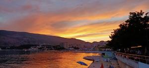 a sunset over a body of water with a city at Appartement Carpe diem vue mer in Herceg-Novi