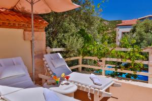 a patio with two chairs and an umbrella at Oyster Residences - Adult Only in Oludeniz