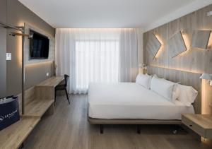 a bedroom with a large white bed and a desk at Senator Gandia in Gandía
