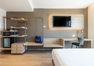 a bedroom with a bed and a tv on a wall at Senator Gandia in Gandía
