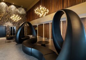 a lobby with black chairs and a chandelier at Senator Gandia in Gandía
