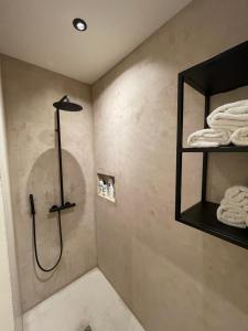 a bathroom with a shower and towels on a wall at 3 Room Luxury Design Apartment in Ghent
