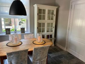 a dining room with a wooden table and chairs at Erve de Kippe. Vrij maar toch dichtbij. in Epse +18 photos