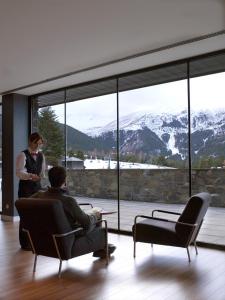 a man sitting in a chair in front of a window at HG La Molina in La Molina