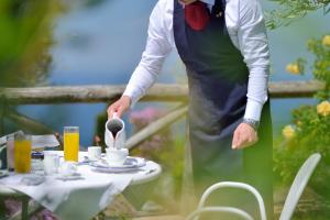 a man stirring a cup of coffee on a table at Hotel Caesar Augustus in Anacapri