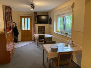 a dining room with a table and chairs and a television at Pension Tom´s Hütte in Nossen