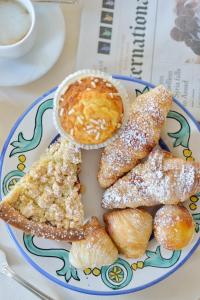 a plate of food with pastries and a cup of coffee at Hotel Caesar Augustus in Anacapri