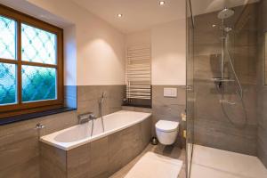 La salle de bains est pourvue d'une baignoire, d'une douche et de toilettes. dans l'établissement Chalet Crown of the Alps by we rent, à Zell am See