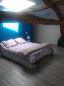 a bed in a room with a blue wall at Maison de campagne à la ferme in Pillac