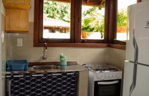 uma cozinha com um lavatório, um fogão e 2 janelas em Casas Barlovento em Barra Grande