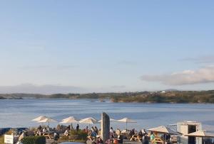 a group of people sitting around a lake with umbrellas at Caisleain Oir Hotel in Annagry