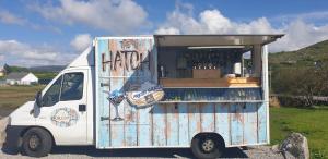 a white food truck parked in a parking lot at Caisleain Oir Hotel in Annagry
