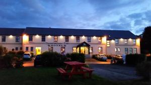 a lit up building with a bench in front of it at Caisleain Oir Hotel in Annagry