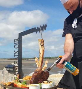 a man is preparing food on a grill at Caisleain Oir Hotel in Annagry