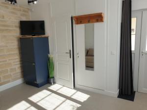 een kamer met een blauwe koelkast en een televisie bij Le Gîte Senlisien in Senlis
