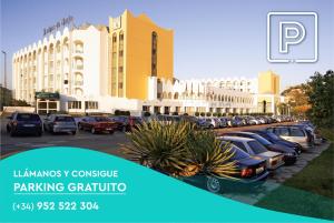 a parking lot with cars parked in front of a building at Ona Marinas de Nerja Spa Resort in Nerja