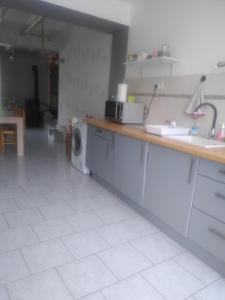 a kitchen with a counter and a washing machine at Maison de campagne à la ferme in Pillac