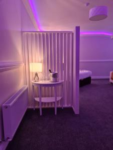 a room with a table with a lamp and a bed at Caisleain Oir Hotel in Annagry