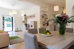a dining room with a table with a vase of flowers at Frascati Country House in Grottaferrata