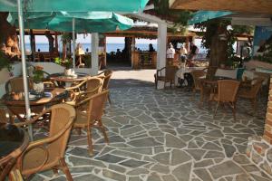 an outdoor patio with tables and chairs and the ocean at Santa Irene in Sougia