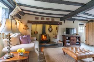 a living room with a couch and a fireplace at Rose Cottage in Evesham