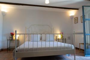a bedroom with a metal bed with white sheets at Frascati Country House in Grottaferrata +32 photos