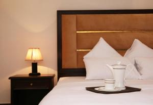 a hotel room with a bed with a tray with a tea pot on it at Luxury 3 Bedrooms Apartment in Lahore
