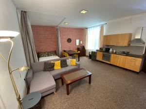 a living room with a couch and a kitchen at Apartments City Liptov in Liptovský Mikuláš