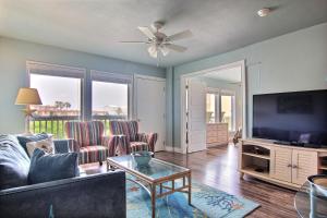 a living room with a couch and a flat screen tv at Sandy Feet 501BH in Port Aransas