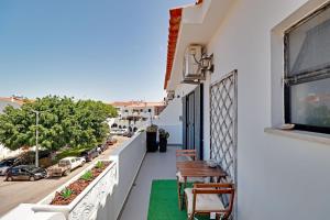 a balcony with a table and chairs and a view of a street at Faro Airport Flats by Homing in Faro