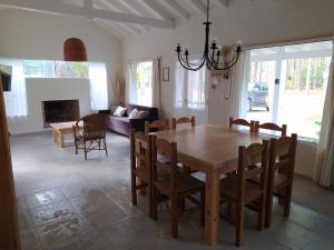 a dining room and living room with a table and chairs at Pinamar Norte Casa Aquiles 8 pax in Pinamar