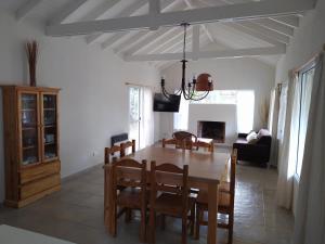 a dining room and living room with a table and chairs at Pinamar Norte Casa Aquiles 8 pax in Pinamar
